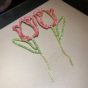 Macro view showing the sparkling pink and green rhinestone details of tulip flower earrings