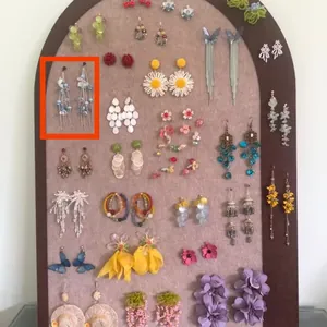 Detailed view of elegant blue beaded tassel earrings displayed on a jewelry board
