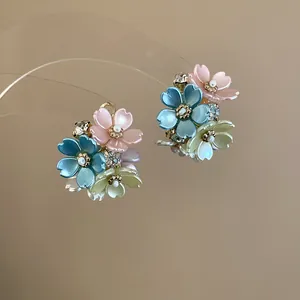 Detailed close-up of elegant floral stud earrings with colorful petals and sparkling crystals