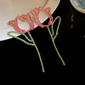 Close-up of elegant tulip earrings with pink and green rhinestones on silver needles.