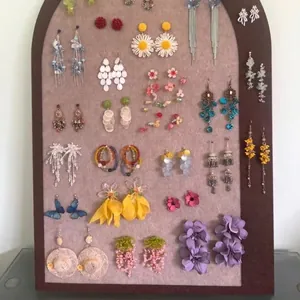 Detail view of elegant purple layered flower earrings on a jewelry display board.