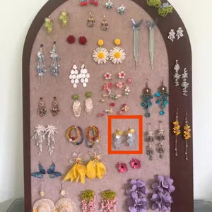 Detailed view of colorful floral and butterfly tassel earrings on a display board