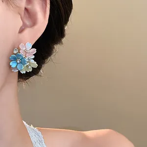 Exquisite close-up view of multi-colored floral stud earrings with tiny sparkling rhinestones