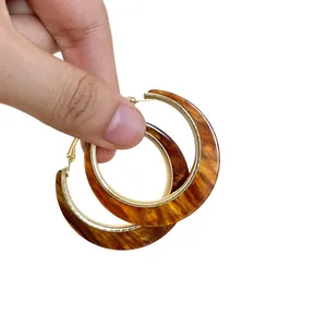 Retro style tortoiseshell resin hoop earrings featuring elegant gold-plated metal edges