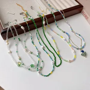 Detail view of various colorful beaded necklaces with pearl and floral heart pendants