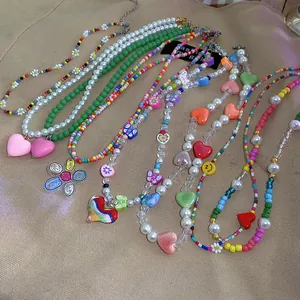 Detail of various colorful beaded necklaces featuring pearls, hearts and flower charms