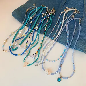 Macro view of assorted colorful pearl and heart beaded necklaces on denim background
