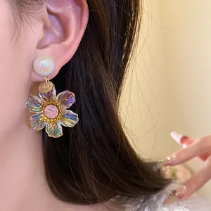 Close-up detail of vintage iridescent resin flower earrings with pink crystal center.