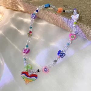 Close-up detail of a colorful beaded necklace featuring a vibrant rainbow heart pendant.