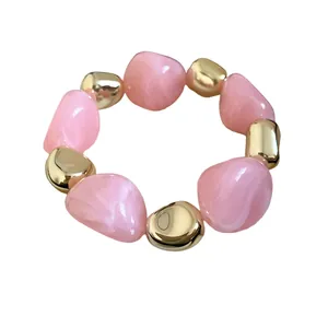 Chic fashion necklace featuring irregular dyed pink beads and gold-tone metallic accents.