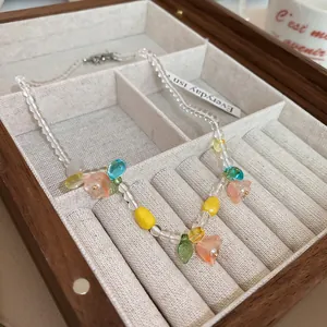 Close-up of a colorful floral beaded necklace with lily of the valley charms in a jewelry box