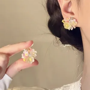 Detailed macro shot of handmade floral cluster earrings with pink and yellow petals