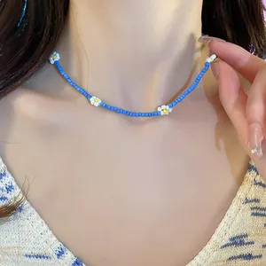 Detailed macro shot of a blue beaded choker necklace with delicate white daisy accents