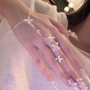 Detailed view of elegant French style zircon butterfly finger bracelet on a woman's hand