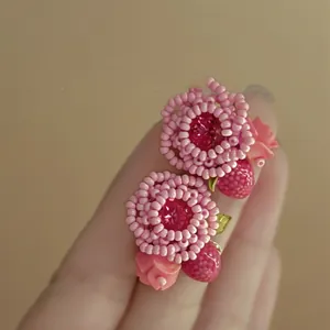 Detailed macro shot of handmade pink flower beaded earrings with crystal center
