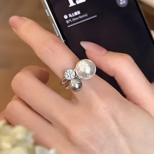 Anello aperto alla moda con perle irregolari e zircone scintillante al dito