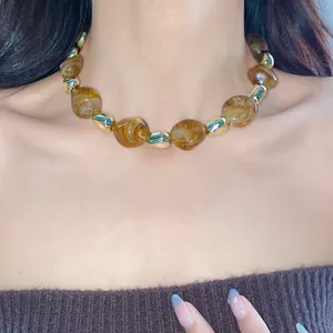 Detailed shot of a vintage irregular marbled beaded choker necklace on an Asian model