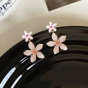Detailed view of pink flower cluster drop earrings with bead petals and rhinestones.