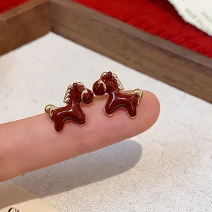Close-up detail of cute brown enamel horse stud earrings with premium 18K gold plating