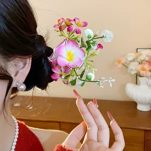 Détail d'une épingle à cheveux en tissu à fleurs douces sur un chignon élégant
