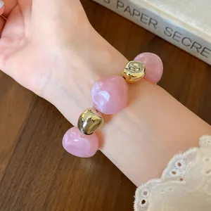 Detail shot of pink marble dyed and gold irregular beaded fashion bracelet on wrist