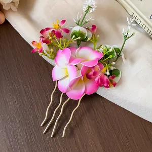 Gros plan d'un pic à cheveux élégant avec fleurs en tissu rose et broches dorées