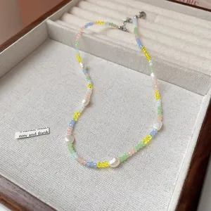Close-up detail of a vibrant multi-colored beaded necklace featuring natural pearls