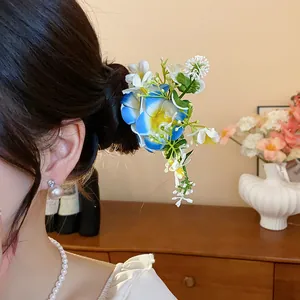 Vue détaillée d'une épingle à cheveux fleurie en tissu bleu et blanc dans un chignon.