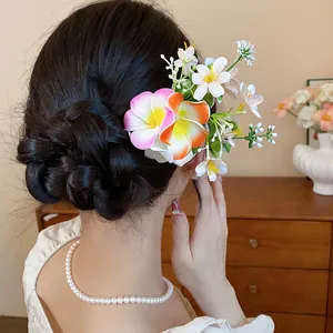 Vue arrière d'un élégant pic à cheveux floral avec frangipanier vibrant et petites fleurs.