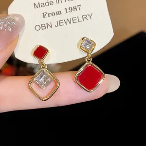 Detailansicht der 18k vergoldeten geometrischen Ohrringe mit roter Emaille