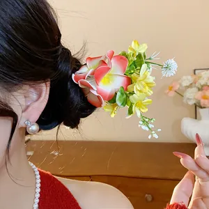 Détail d'un pic à cheveux en tissu avec fleurs porté dans un chignon chic