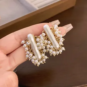 Primo piano di orecchini a lobo retrò francesi con eleganti perle artificiali e oro