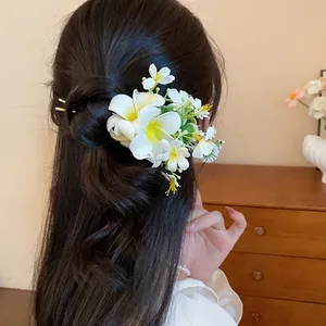 Vue détaillée montrant une épingle à cheveux élégante avec fleurs de frangipanier
