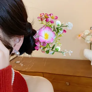 Gros plan détaillé d'une épingle à cheveux élégante en fleurs de tissu rose sur un chignon