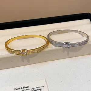 Vue rapprochée de joncs ovales dorés et argentés avec des strass pavés délicats