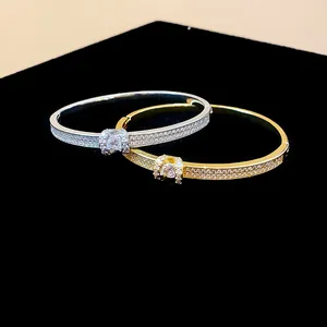 Détail de deux joncs ovales plaqués or et argent avec cristaux sertis en pavé