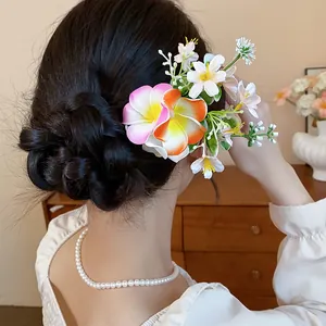 Vue détaillée d'une épingle à cheveux fleur en tissu sur un chignon tressé élégant