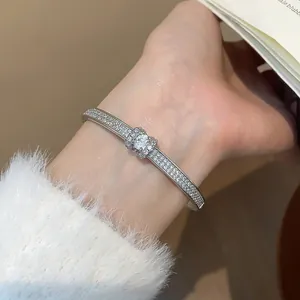 Gros plan sur un élégant jonc ovale argenté orné de strass scintillants
