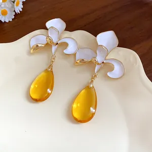 Close-up detail of vintage flower earrings featuring vibrant yellow water drop pendants