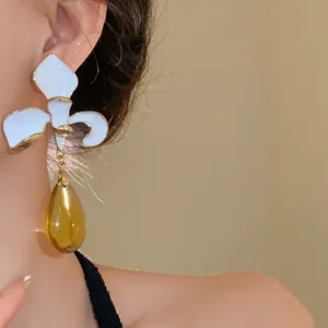 Elegant vintage white floral drop earrings featuring a translucent amber water drop pendant