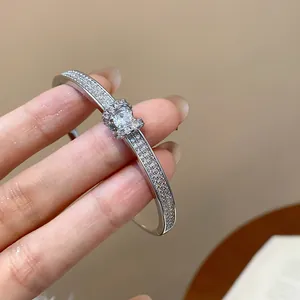 Détail de l'élégant jonc ovale argenté incrusté de strass scintillants sur main