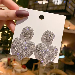 Glamorous heart-shaped statement earrings featuring full sparkly rhinestone embellishment.