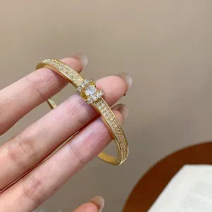 Détail élégant d'un jonc ovale plaqué or orné de cristaux pavés micro-étincelants