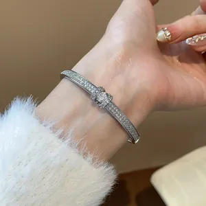 Gros plan d'un élégant bracelet ovale plaqué or avec des diamants pavés scintillants.