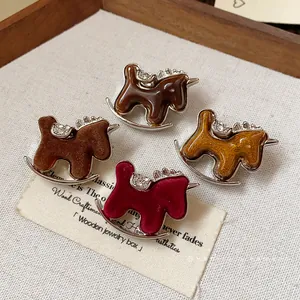 Elegant rocking horse brooches featuring rhinestones and various flocked resin textures