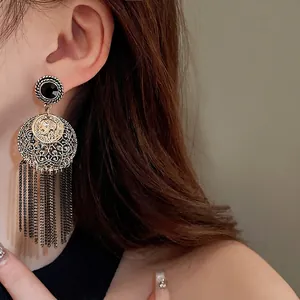 Vintage style round coin tassel earrings with black stud for an elegant retro fashion look.