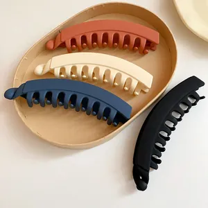 Gros plan de barrettes banane en acrylique mat en terre cuite, crème, bleu marine et noir