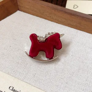Close-up of a red flocked rocking horse brooch with sparkling rhinestone details