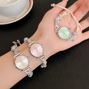 Detailed view of three elegant woven ceramic bead quartz watches on a lady's hand.