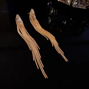 Detailed view of long gold tassel earrings with multiple metallic snake chains